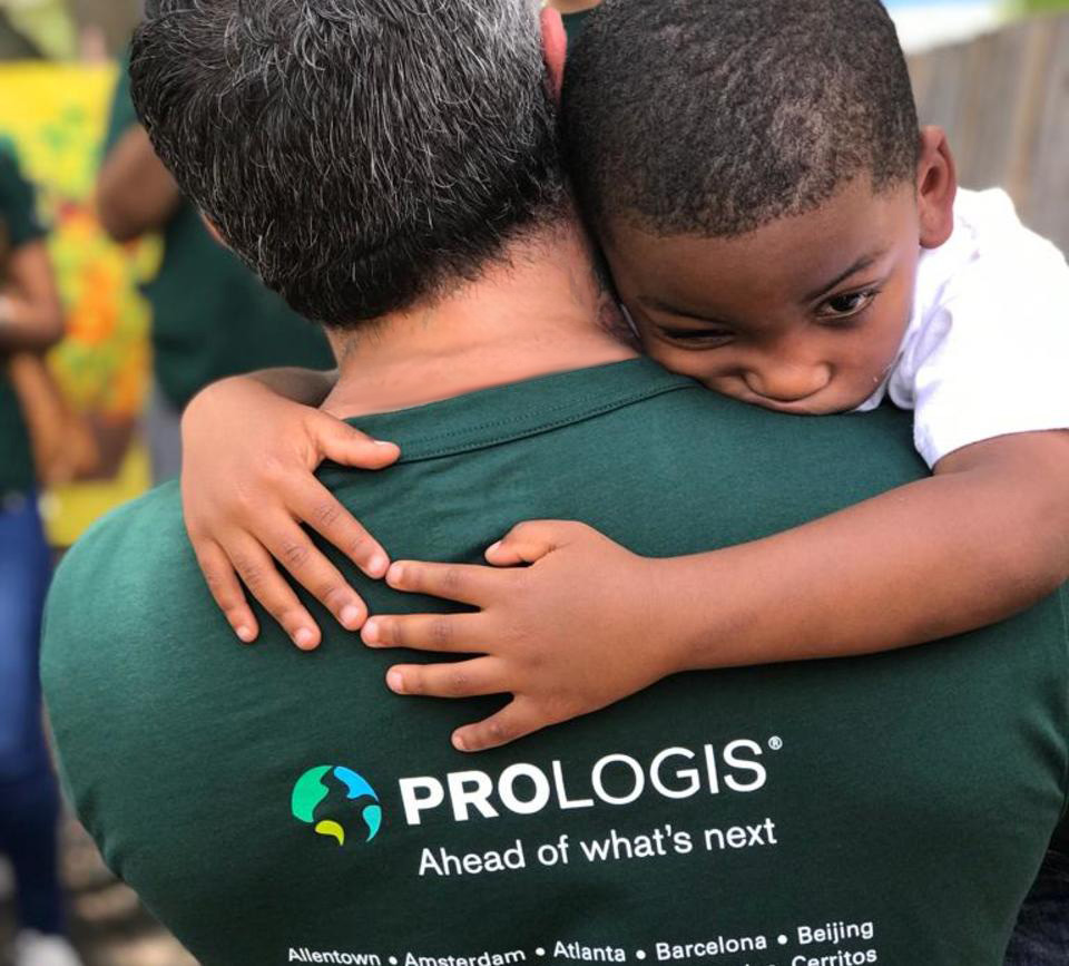 Un niño abraza a un empleado de Prologis en un IMPACT Day